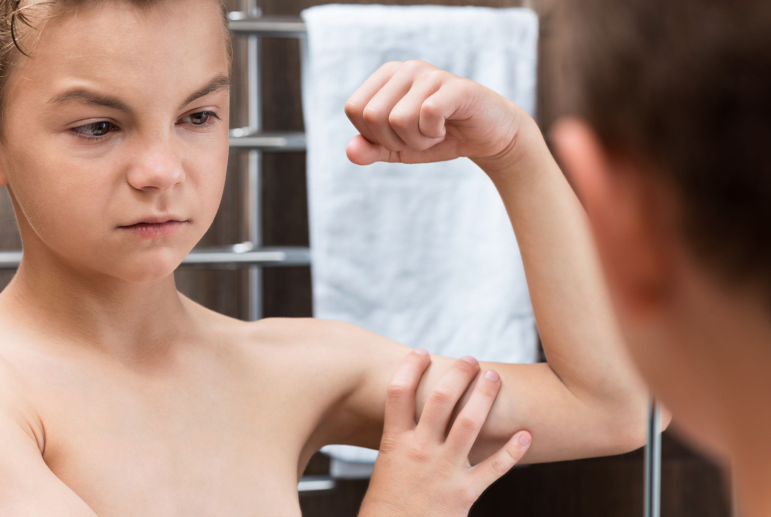 46780883 – closeup of a teen boy in the bathroom showing his arm muscles