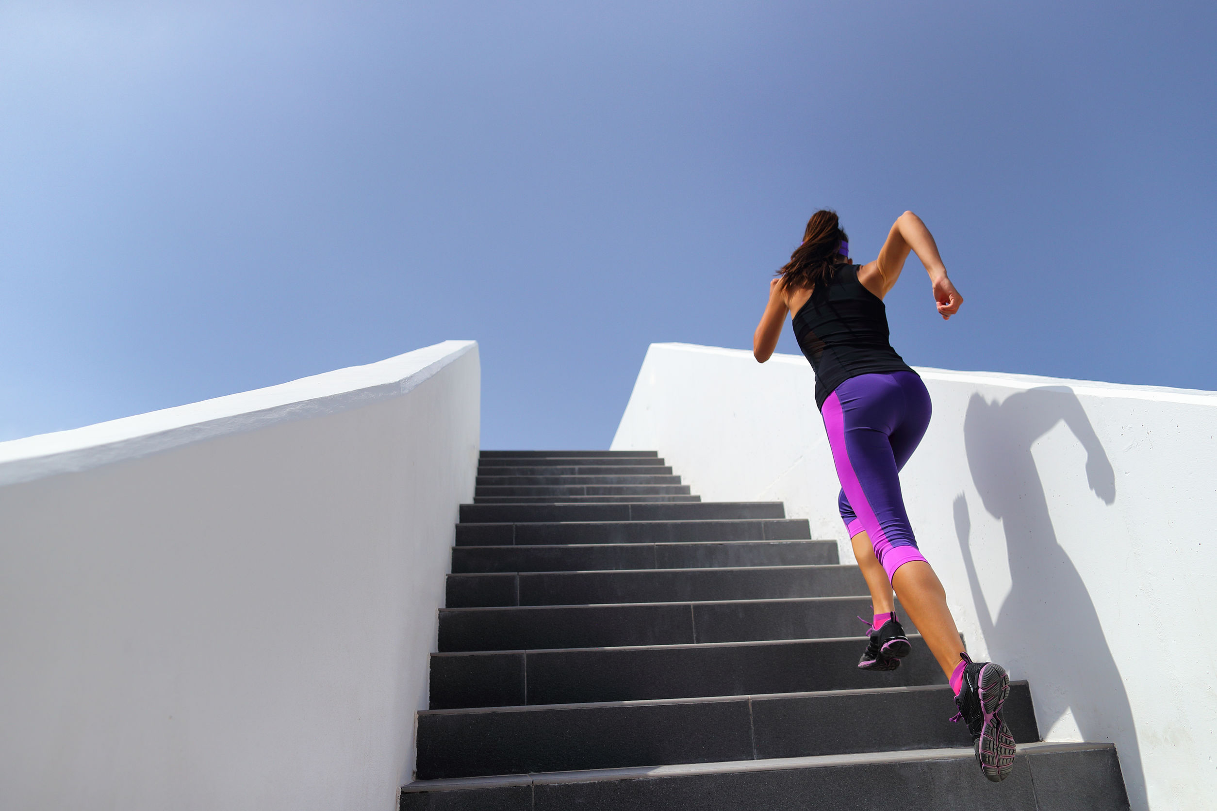 Stairs running workout woman training cardio at gym. Fitness girl exercising legs muscles outdoors with explosive exercises.